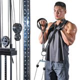 A man in black tank top and shorts uses the Bells of Steel RocIT Tricep Strap attached to a cable machine with visible weights while performing bicep curls.
