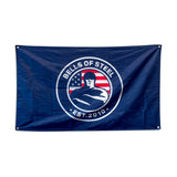 The Bells of Steel Flags feature a navy blue design with a circular logo of a muscular figure, an American flag backdrop, and "Bells of Steel Est. 2010"—an inspiring addition to any home gym.