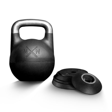 A Bells of Steel Mark Wildman Adjustable Kettlebell with a sleek black body and a silver handle stands upright beside several matching black weight plates on a white background, designed in the competition-style preferred by Mark Wildman for versatile training routines.