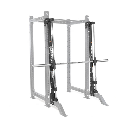 The Bells of Steel Smith Machine Rack Attachment, shown in silver with a barbell, is designed for weightlifting and strength training. The equipment is displayed against a plain white background.
