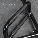 A close-up of the Bells of Steel Open Trap Bar (Hex Bar) with fully knurled handles and rotating sleeves, lying on a gray stone floor. Text reads "Fully knurled handles.